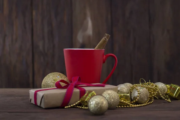 Csésze forró tea, fahéj, csomagolópapír, dekorációs játékok — Stock Fotó