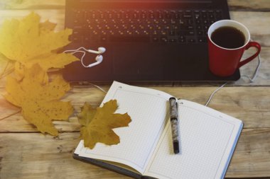 Çalışma alanı kahve, laptop, günlüğü, kalem, sonbahar yaprakları ile. Busine