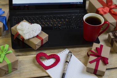 Sevgililer günü için hazırlık. Dizüstü bilgisayar, bir fincan kahve, hediyeler 