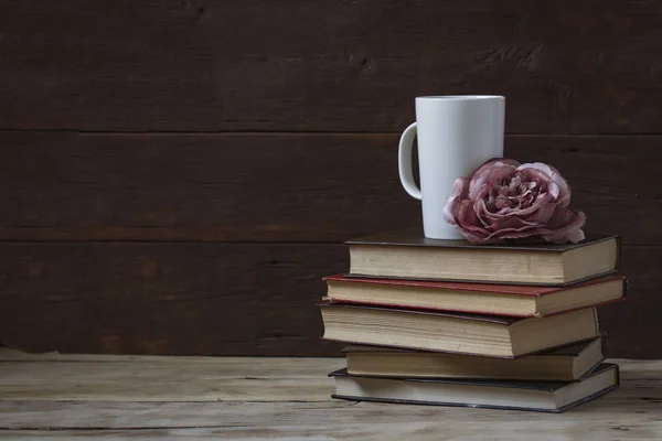 Composição em um fundo de madeira. Gema de rosa, livros e um branco — Fotografia de Stock