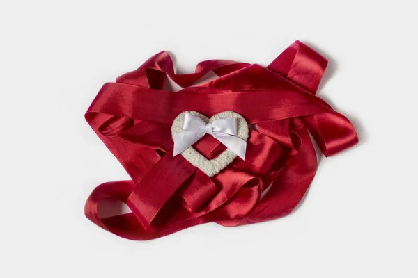 Κόκκινη κορδέλα σε άσπρο φόντο. Λευκή καρδιά χειροποίητο φιόγκο σε λευκό — Φωτογραφία Αρχείου
