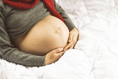 Karın hamile bir kadının bir kazak ve eşarp