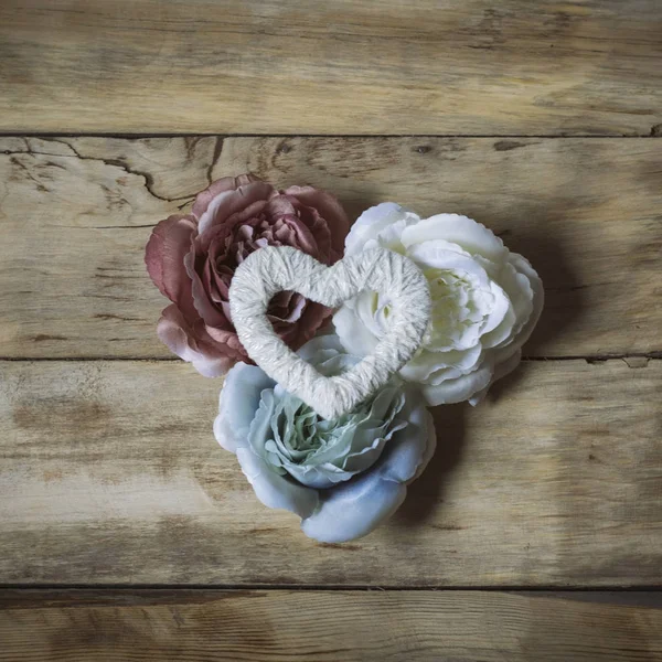 Drie rozen en hart handgemaakte op een houten achtergrond. Bovenaanzicht — Stockfoto