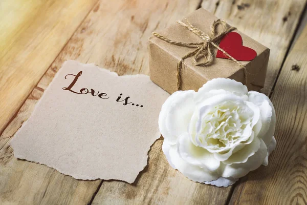 Inscripción en un papel El amor es... Caja de regalo con un oído — Foto de Stock