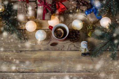 Noel Baba, fincan çay, hediyeler, çam kozalakları ve çelenk bir wo üzerinde