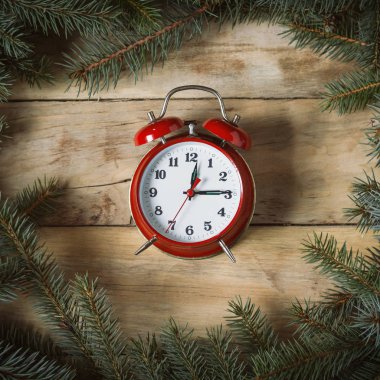 Güzel bir ahşap arka plan üzerinde kırmızı saat. Çam dalları