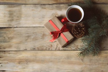 Paketlenmiş hediye, bir fincan çay, Ladin koni ve Ladin dalları. FL