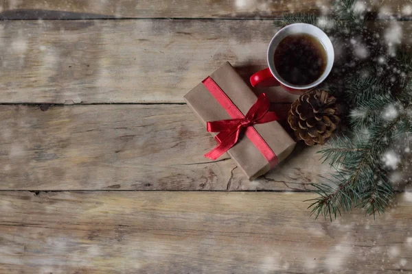 Packaged gift, a cup of tea, spruce cone and spruce branches. Sn