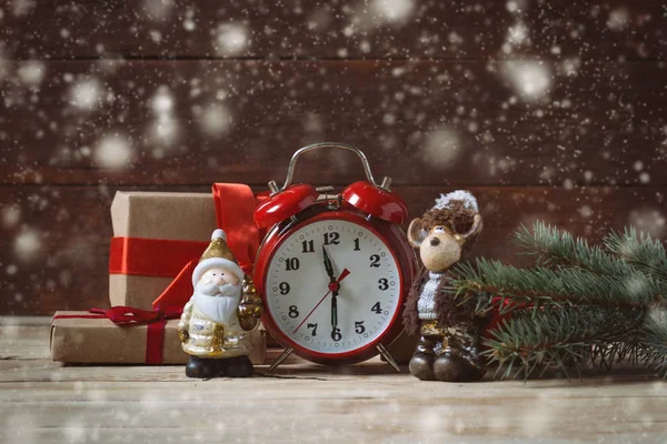 Packaged gifts, Christmas toys, red clock and fir cones on a woo