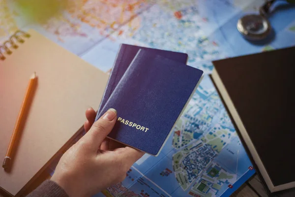 Ręka trzyma dwa paszporty na mapie tła. Kompas, — Zdjęcie stockowe