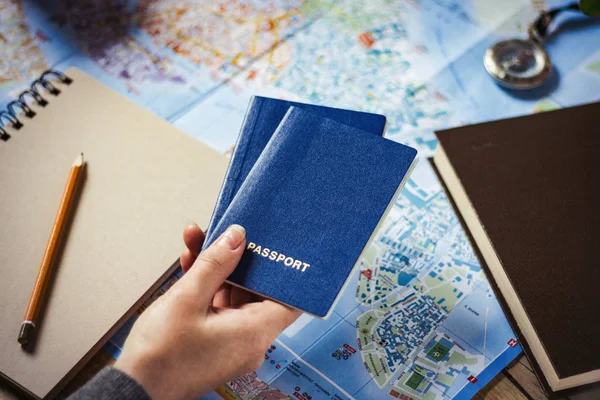 Ręka trzyma dwa paszporty na mapie tła. Kompas, — Zdjęcie stockowe