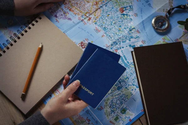 Concept de voyage. La main d'une femme porte deux passeports. Bloc-notes, stylo — Photo