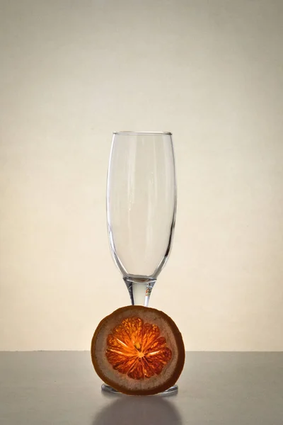 Jednu prázdnou sklenici šampaňského a kousek suché grapefruitu — Stock fotografie