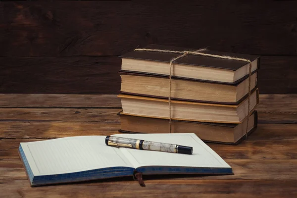 Una pila di libri legati con una corda, un diario, una penna su una ba di legno — Foto Stock