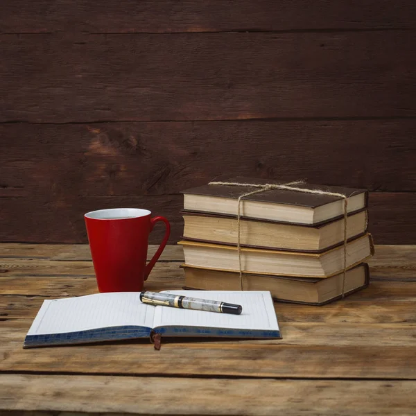 Un mucchio di libri legati con una corda, un diario, una penna e una tazza di — Foto Stock