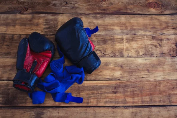 Guantes de boxeo negros y vendas de boxeo azul en un suelo de madera —  Fotos de Stock