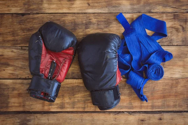 Imagen de guantes de boxeo y vendajes adhesivos en el suelo de madera —  Fotos de Stock