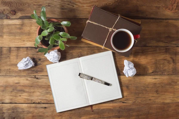 Diario e penna, tappo con caffè su una pila di libri su una t di legno — Foto Stock