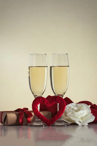 İki kadeh şampanya, hediye paketi, el yapımı kırmızı bir kalp ile bir — Stok fotoğraf