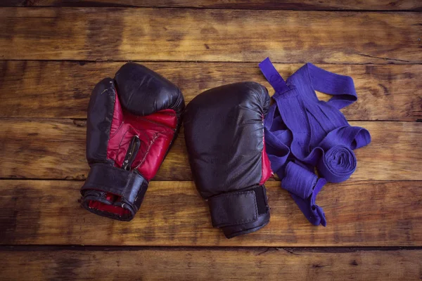 Alte schwarze Boxhandschuhe auf alten hölzernen Grunge-Hintergrund Cop — Stockfoto