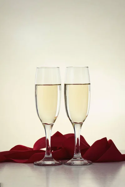 İki kadeh şampanya ve kırmızı kurdele ile — Stok fotoğraf
