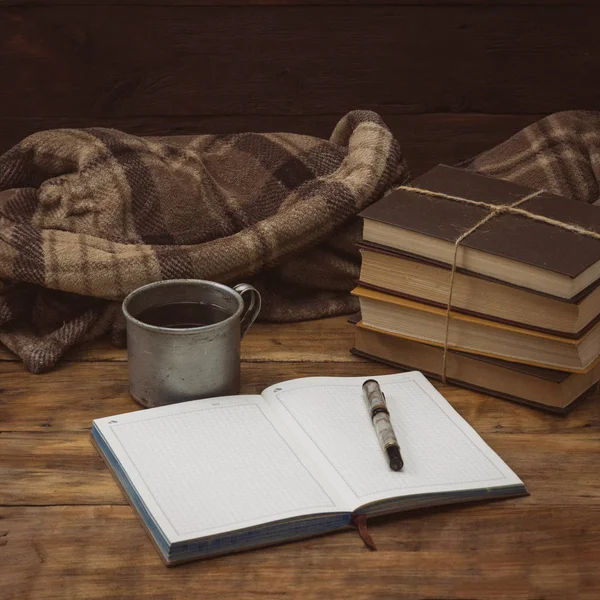 Un foglio di carta, libri, una tazza di alluminio antico con caffè e — Foto Stock