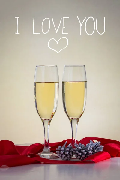 İki kadeh şampanya, bir kırmızı kurdele ile çam kozalakları. Eklendi — Stok fotoğraf