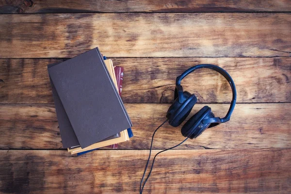 Concept audioboek. Hoofdtelefoons en een stapel boeken op een houten Ba — Stockfoto