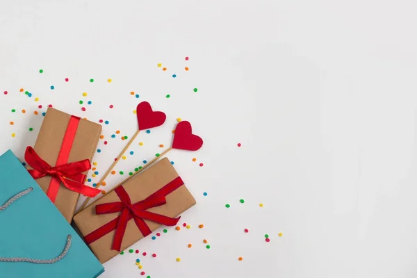 Corazones en palos, dos regalos, paquete de regalo en el fondo blanco — Foto de Stock