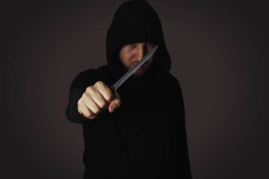 Siyah arka planda kapüşonlu bir hırsız.