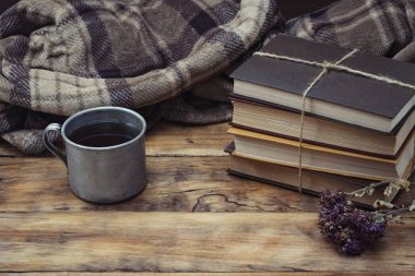Sıcak çay veya kahve, sıcak ekose, bir yığın kitap ti ile metal Kupası