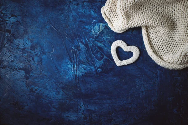 White scarf and white heart on a dark blue background