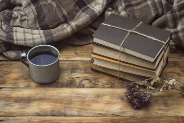 Sıcak çay veya kahve, sıcak ekose, bir yığın kitap ti ile metal Kupası