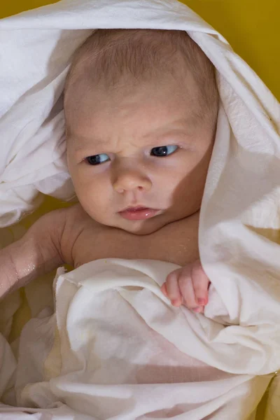 Neugeborene in der weißen Windel baden in der gelben Badewanne. flache Lage — Stockfoto