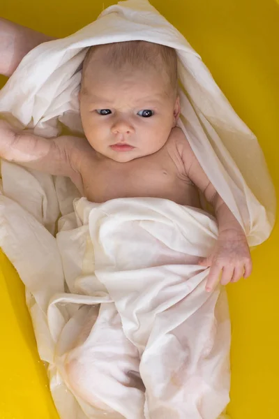 Recién nacido en el baño de película blanca en la bañera amarilla, sostiene a mamá. Top Vi —  Fotos de Stock