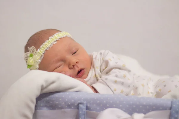 Милая новорожденная девочка с красивыми голубыми глазами на белом спинке — стоковое фото
