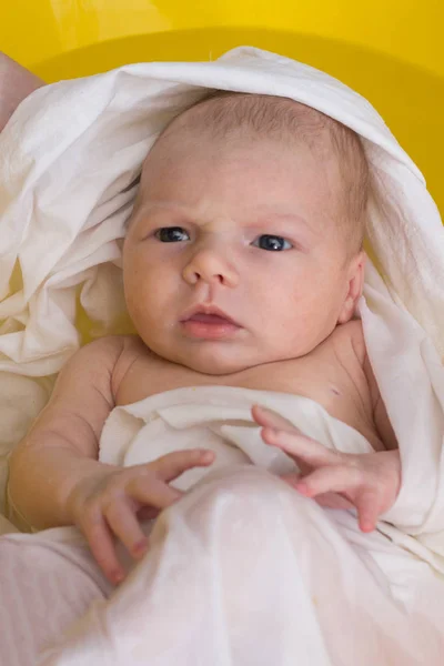 Серьезный новорожденный в купании в белом кино — стоковое фото