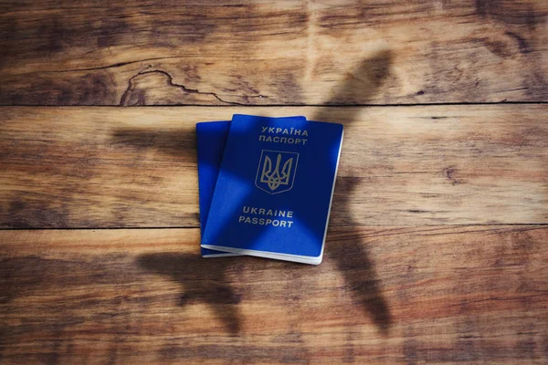 Ukrainian passport and airplane on a wooden background. Concept — Stock Photo, Image