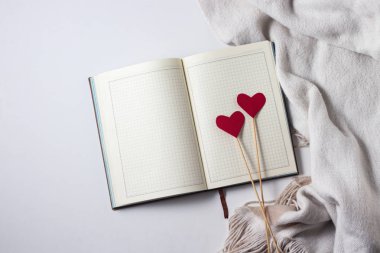 İki kalp, eşarp ve günlük beyaz bir arka plan üzerinde sopa üzerinde. Kopya