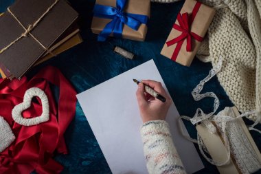 Kalem ve kağıt ile el. Paketlenmiş hediyeler, kitaplar, 