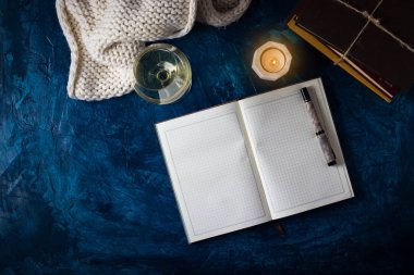 Bardak beyaz şarap, açık günlük, kalem, mumlar, buruşuk kağıt, 