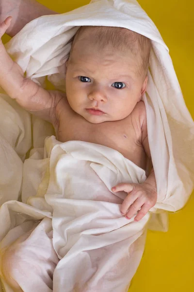 Neugeborenes in Weißfolie badet in gelber Badewanne, hält Mama. flach l — Stockfoto