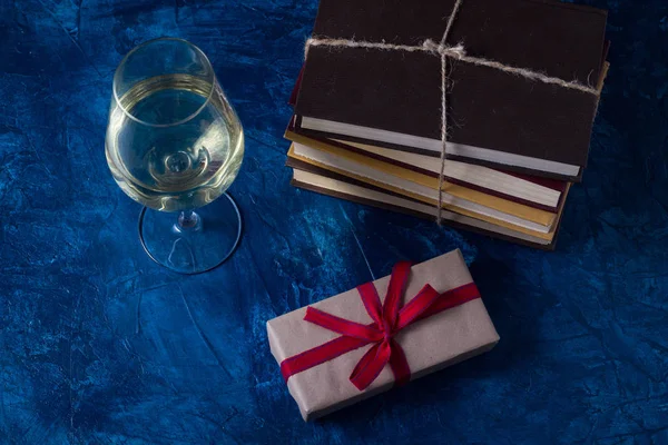 グラスにワイン、書籍、青の背景にギフトを満載 — ストック写真