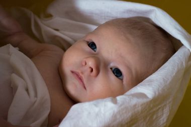 Yenidoğan beyaz bebek bezi içinde sarı banyoda banyo. Yakın çekim. 