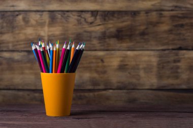 Turuncu Market ahşap arka plan üzerinde renkli kalemler. Kopya spa