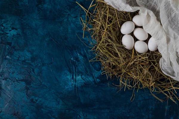 Csirke tojás a fészek és a kék alapon fehér szövet. — Stock Fotó