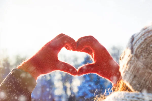 Women\'s Hands in Red Glove Folded in Heart Shape. Winter Concept