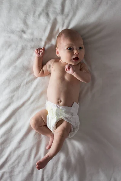 Little Baby in a White Nappy mente em um cobertor branco. Branco de volta — Fotografia de Stock