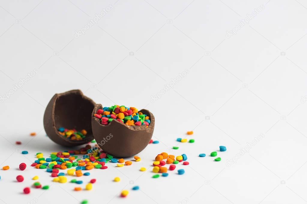 Broken Chocolate Easter egg with multi-colored candy decorations