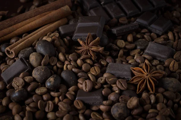 Black Chocolate, Spices, Coffee Grain on a Wooden Background